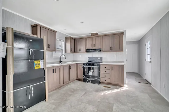 a kitchen with stainless steel appliances granite countertop a refrigerator a stove and a sink