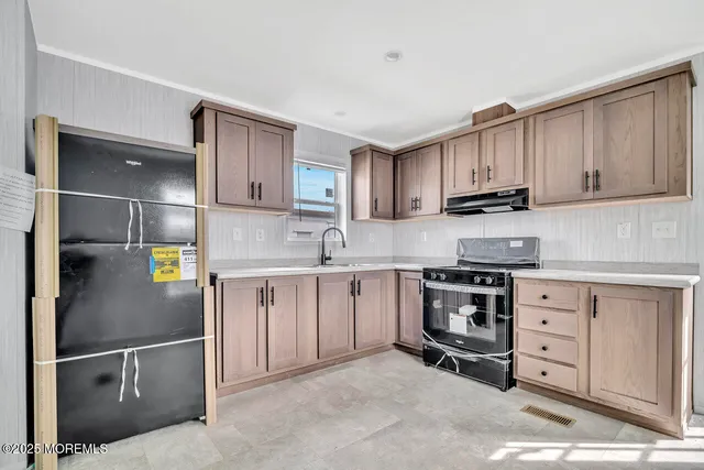 a kitchen with stainless steel appliances granite countertop a stove a sink and a refrigerator