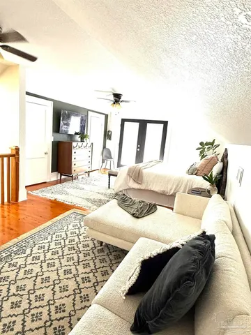 a bedroom with a bed and wooden floor
