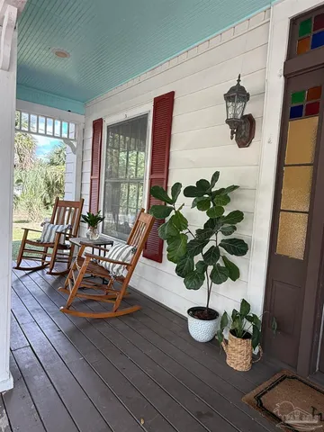a dining room with furniture potted plants and wooden floor