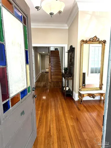 a view of a hallway with wooden floor and door