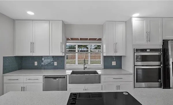 a kitchen with granite countertop a sink stainless steel appliances and cabinets