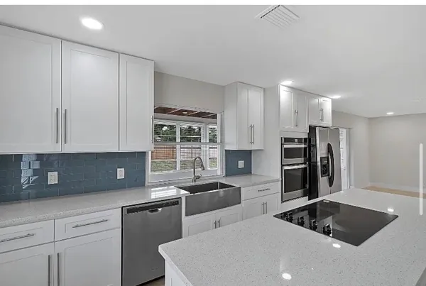 a kitchen that has a sink cabinets counter space and stainless steel appliances