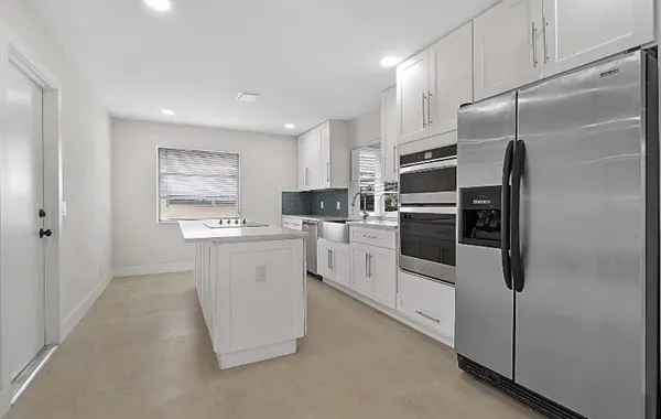 a kitchen with white cabinets and stainless steel appliances