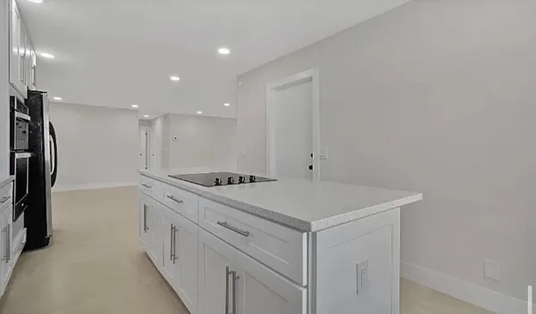 a view of kitchen with refrigerator and windows