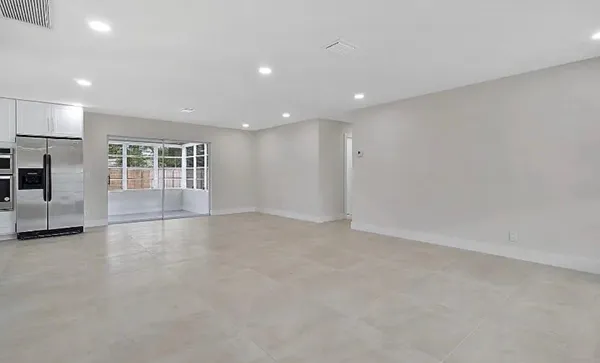 a view of an empty room with a kitchen