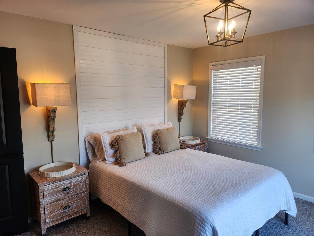 330 Gull Cove Brigantine, NJ 08203 - Photo 21 of 34 a bedroom with a bed a chandelier and a window