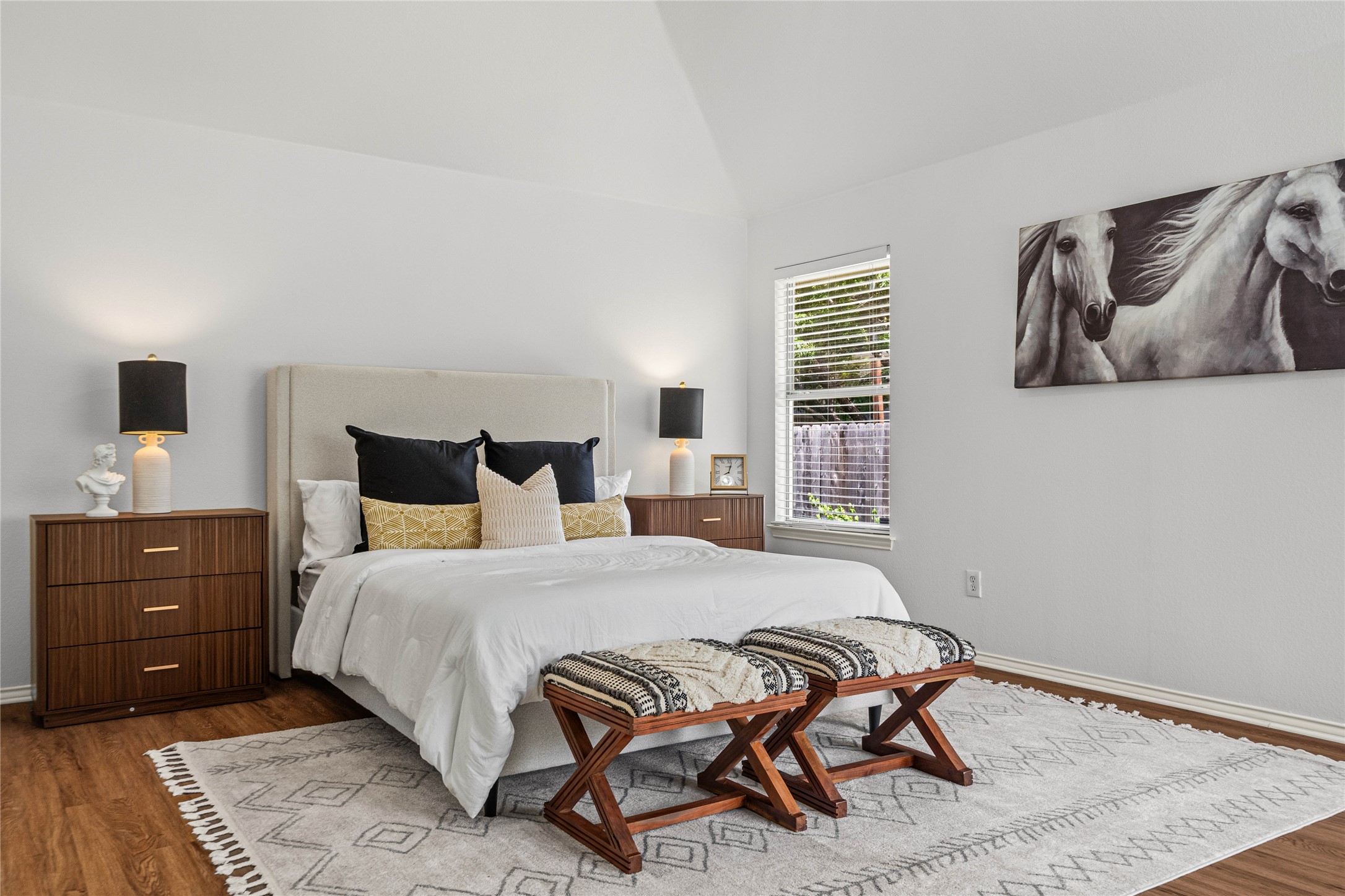 2920 Warwick Way Austin, TX 78748 - Photo 5 of 36 A restful primary bedroom showcases warm wood flooring, vaulted ceiling, and fresh interior paint