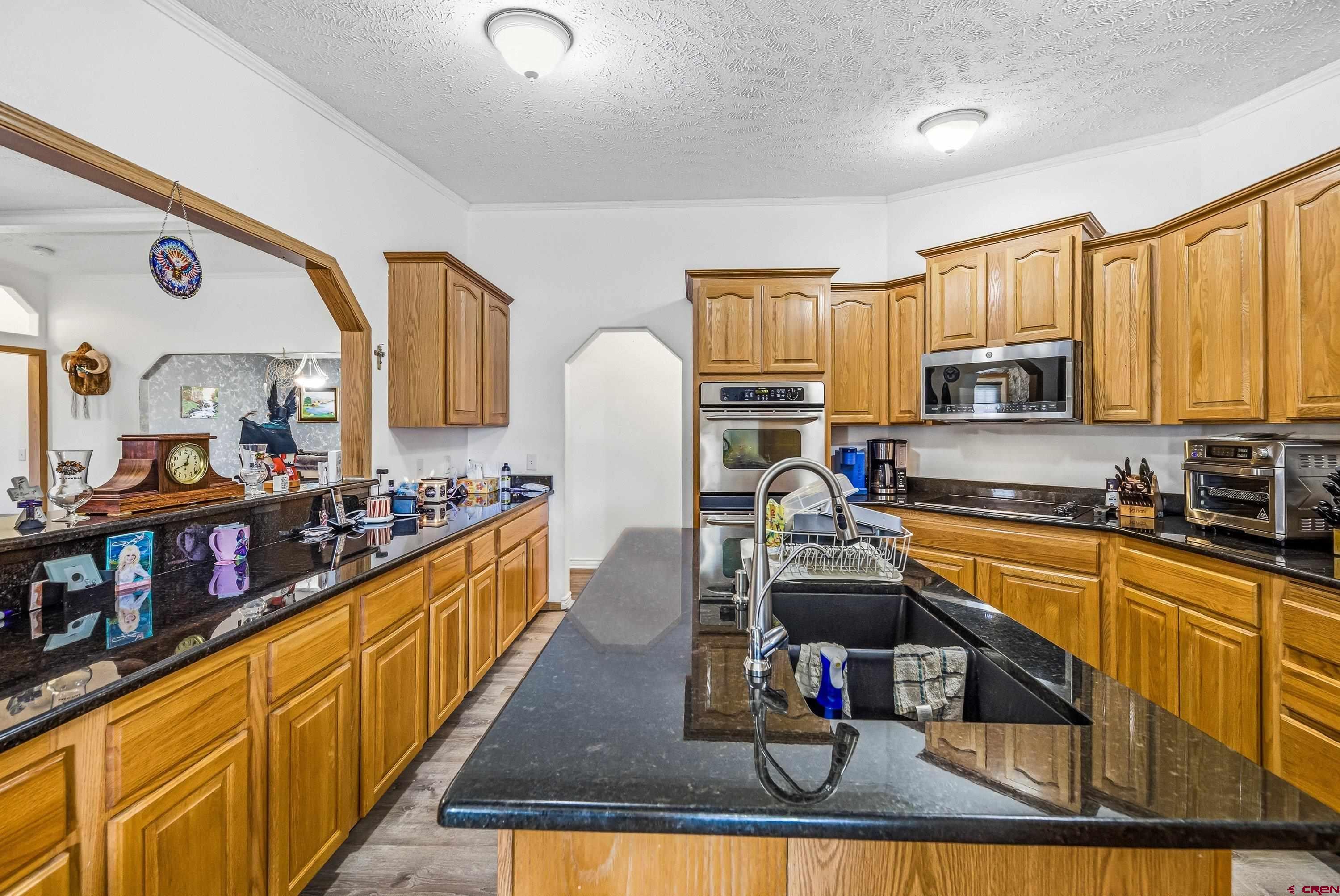 14473 Deer Run Road Delta, CO 81416 - Photo 5 of 26 a kitchen with stainless steel appliances granite countertop a stove top oven a sink dishwasher and cabinets with wooden floor