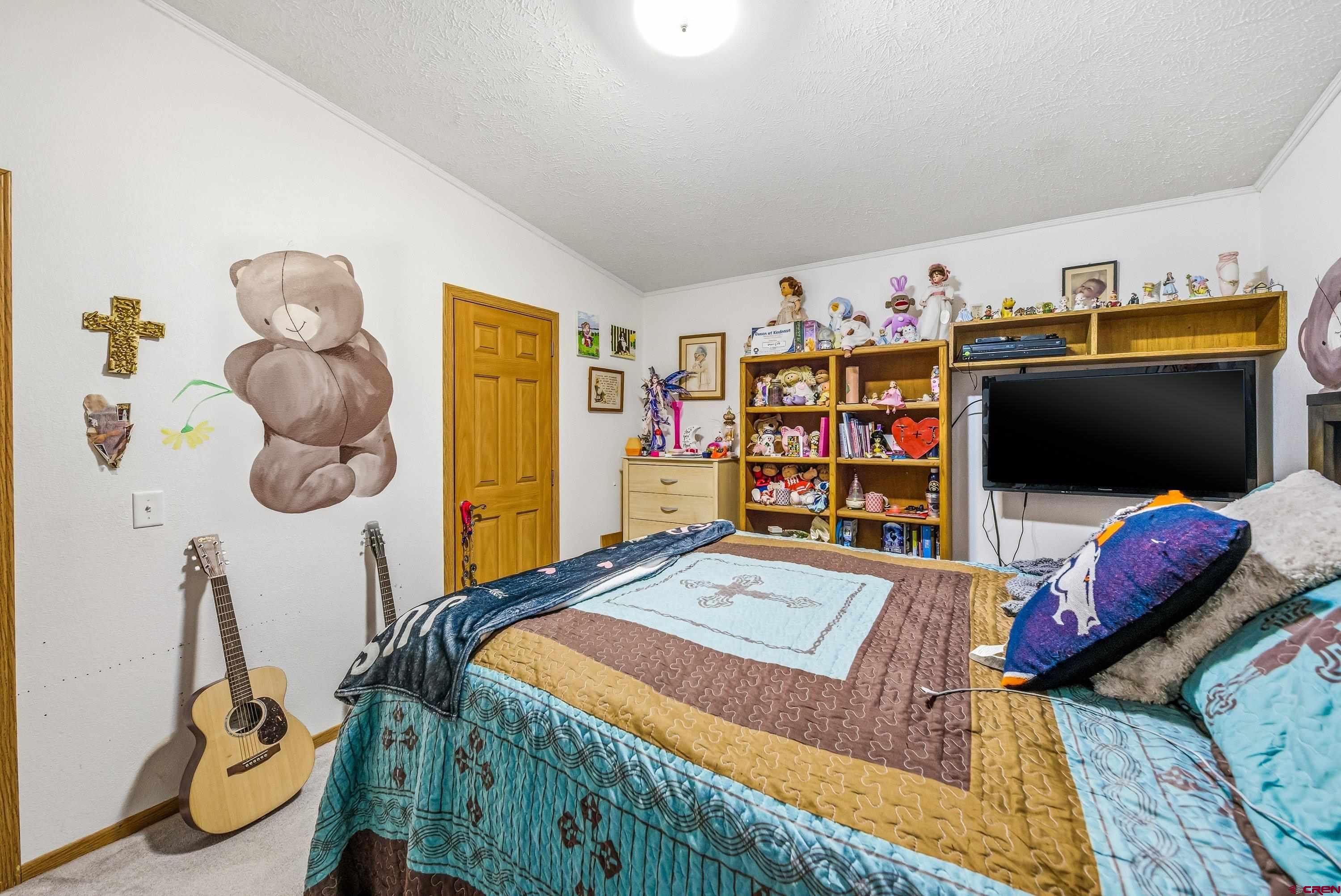 14473 Deer Run Road Delta, CO 81416 - Photo 10 of 26 a bedroom with a bed and a flat tv screen