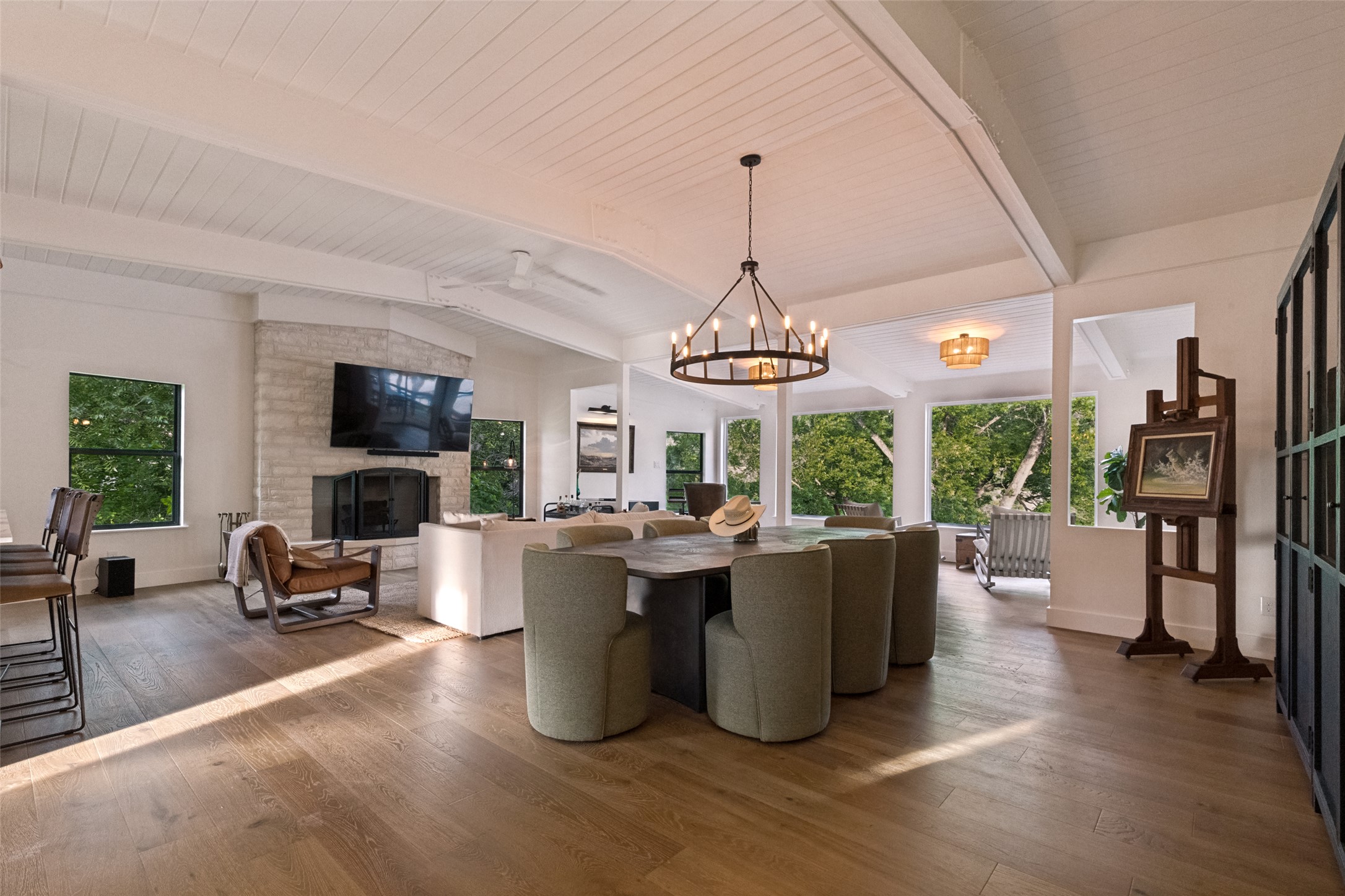 303 Lago Verde Road Austin, TX 78734 - Photo 13 of 39 An open-concept living and dining area boasts rich hardwood flooring and a stone-faced fireplace.
