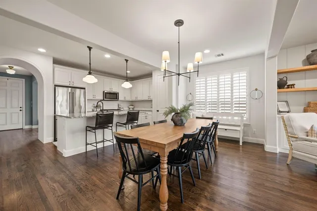 a view of a dining room and livingroom with furniture wooden floor a chandelier