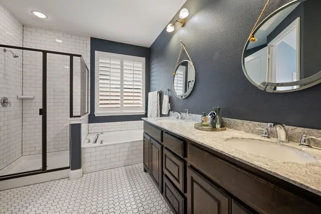 a bathroom with a granite countertop sink a mirror and a shower