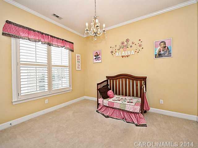 342 Miners Cove Way Fort Mill, SC 29708 - Photo 13 of 16 a bed sitting in a bedroom next to a window with a chandelier