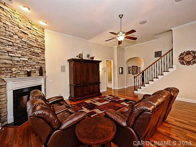 342 Miners Cove Way Fort Mill, SC 29708 - Photo 6 of 16 a living room with furniture a fireplace and a chandelier