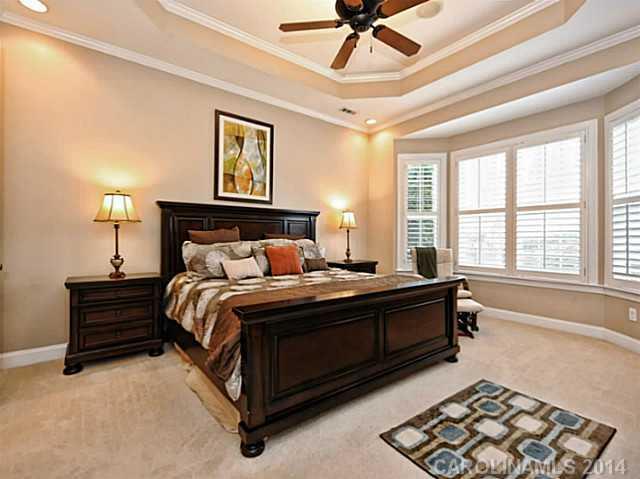 342 Miners Cove Way Fort Mill, SC 29708 - Photo 9 of 16 a spacious bedroom with a bed and a chandelier