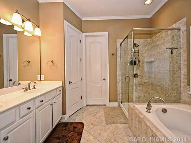 342 Miners Cove Way Fort Mill, SC 29708 - Photo 10 of 16 a spacious bathroom with a shower sink double vanity granite tub shower and mirror