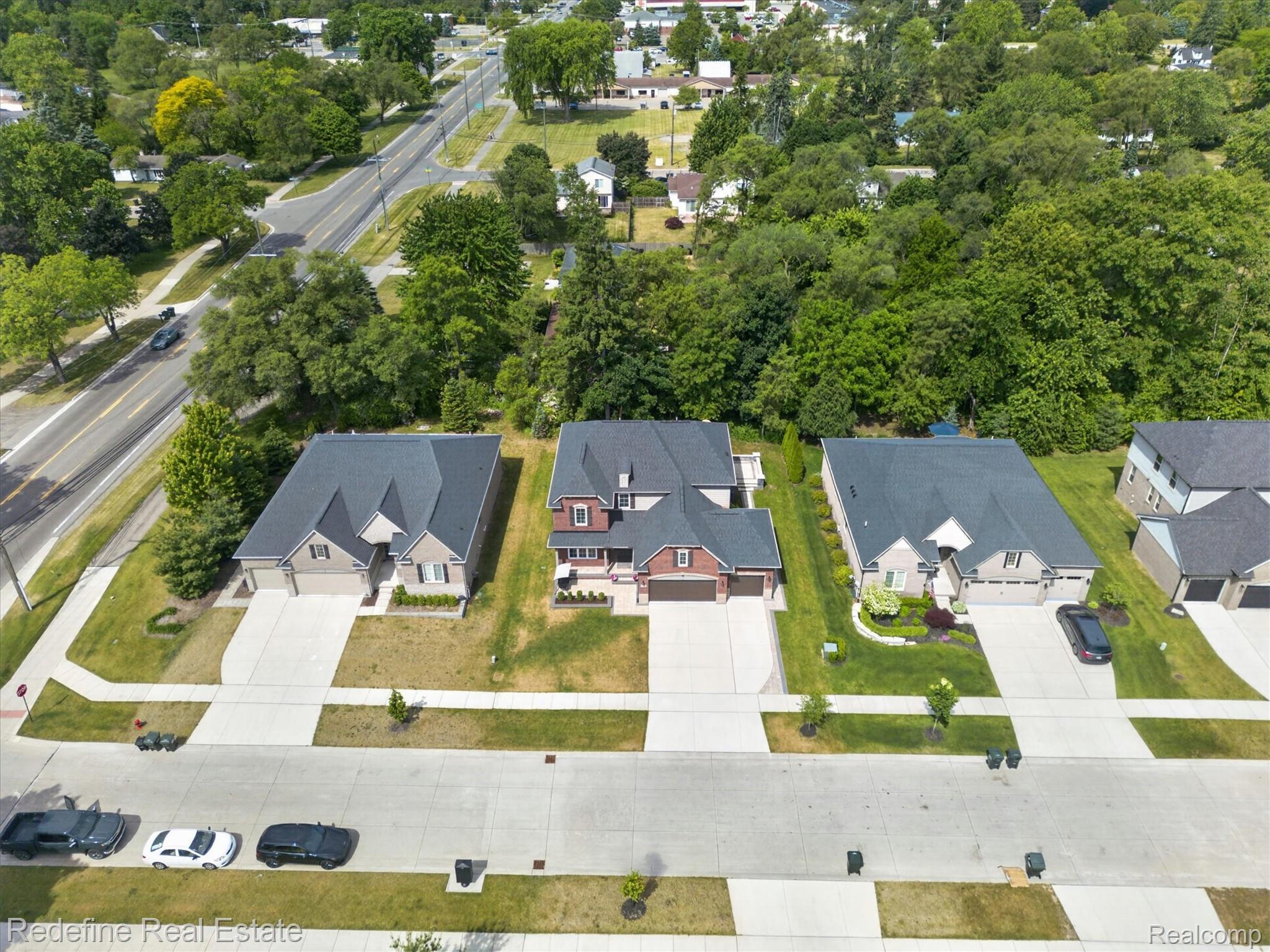 2976 Andlaur Drive Rochester, MI 48307 - Photo 52 of 60 Aerial perspective showcasing a residential property with a multi-gabled roofline, light-toned siding, and an attached two-car garage