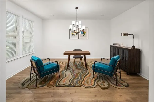 a dining room with furniture a rug and a chandelier