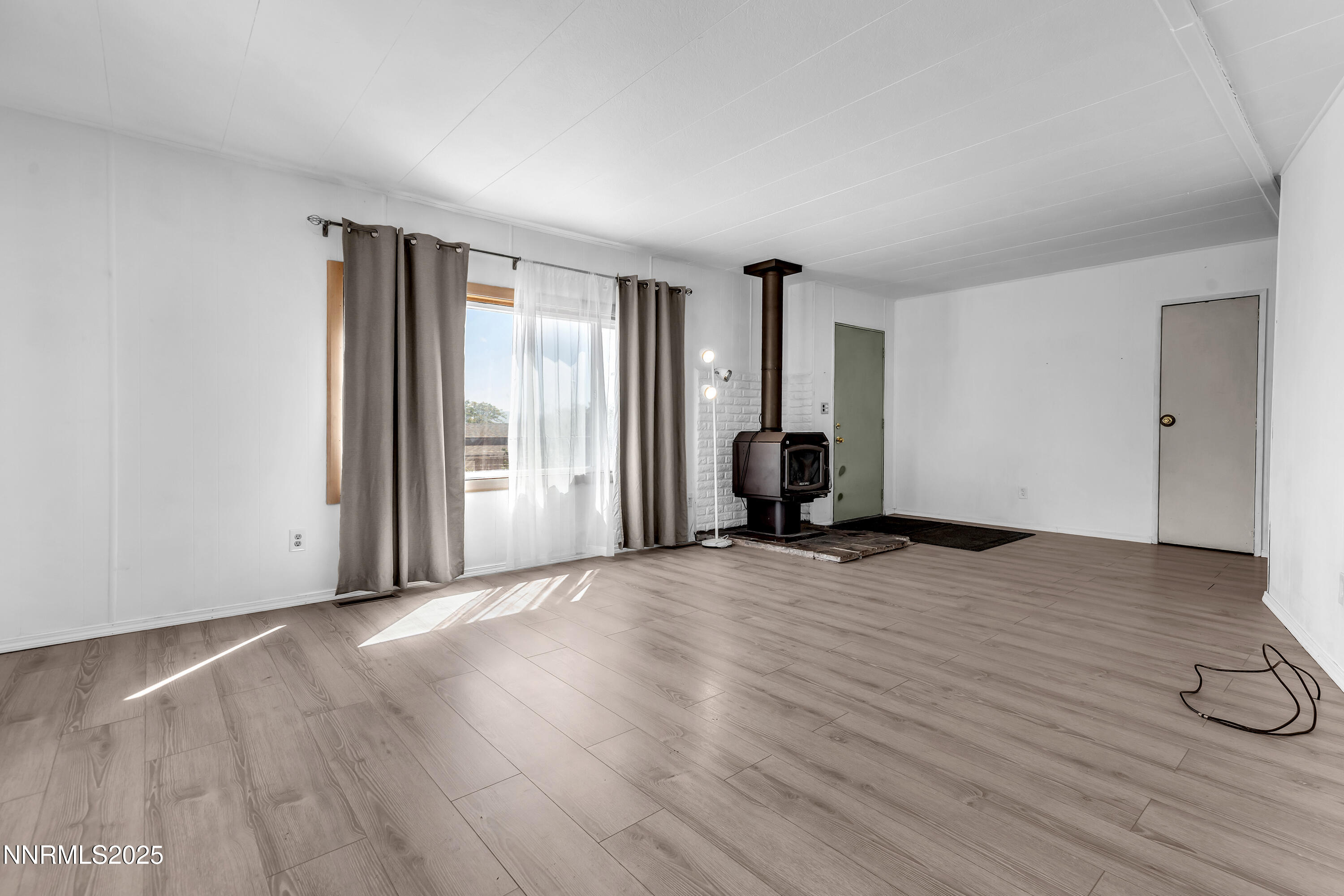 5961 Spring Valley Circle Sun Valley, NV 89433 - Photo 4 of 20 a view of an empty room with wooden floor and a window