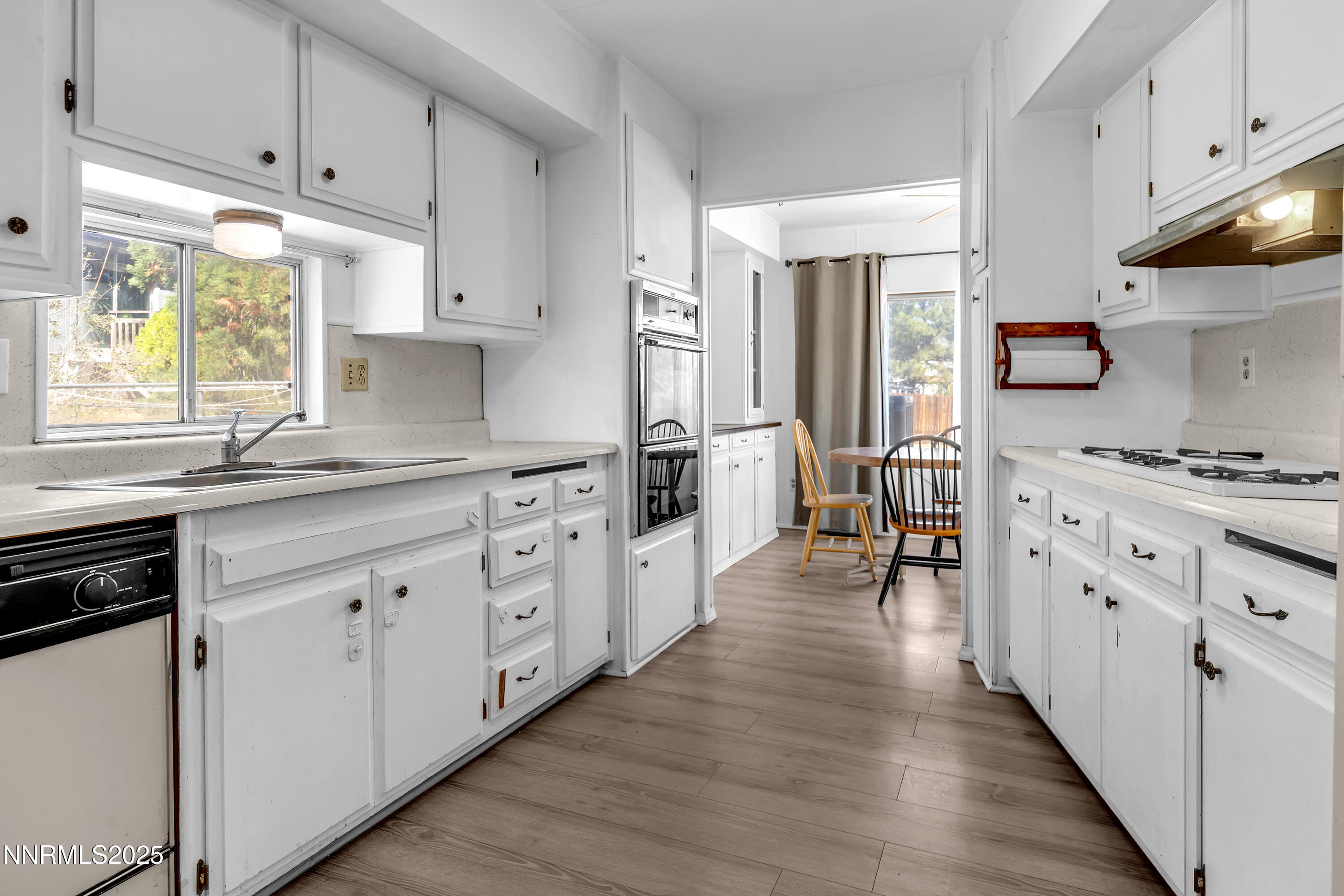 5961 Spring Valley Circle Sun Valley, NV 89433 - Photo 6 of 20 a kitchen with white cabinets and appliances