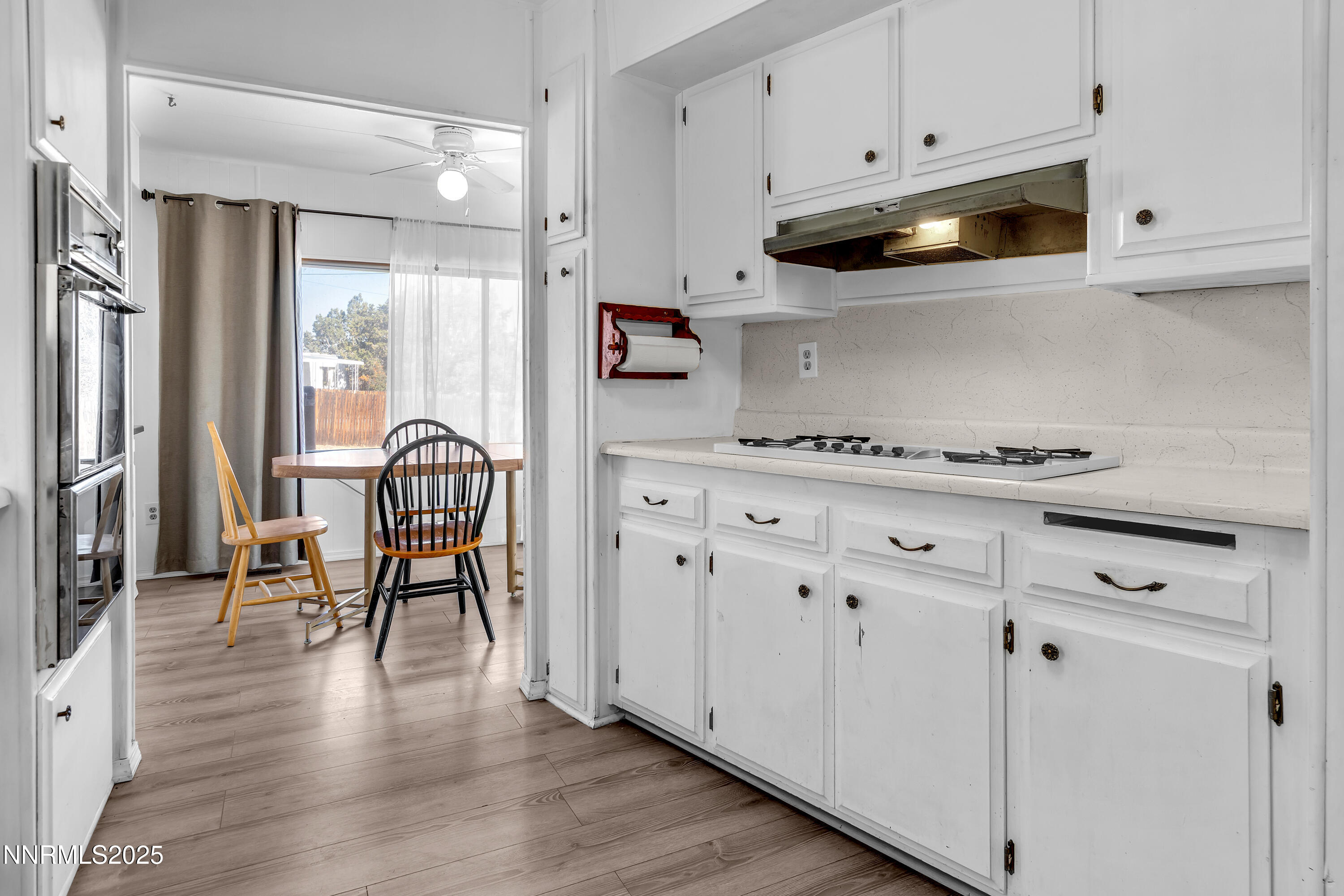 5961 Spring Valley Circle Sun Valley, NV 89433 - Photo 7 of 20 a kitchen with stainless steel appliances white cabinets and wooden floors