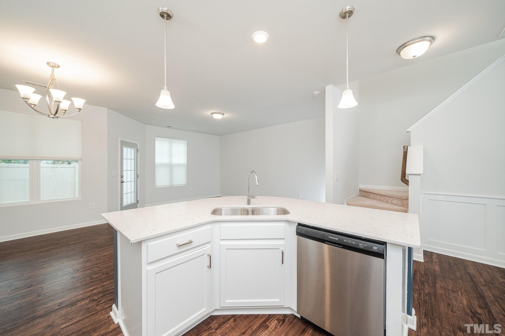 6075 Beale Loop Raleigh, NC 27616 - Photo 6 of 23 a kitchen with a sink dishwasher and white cabinets with wooden floor