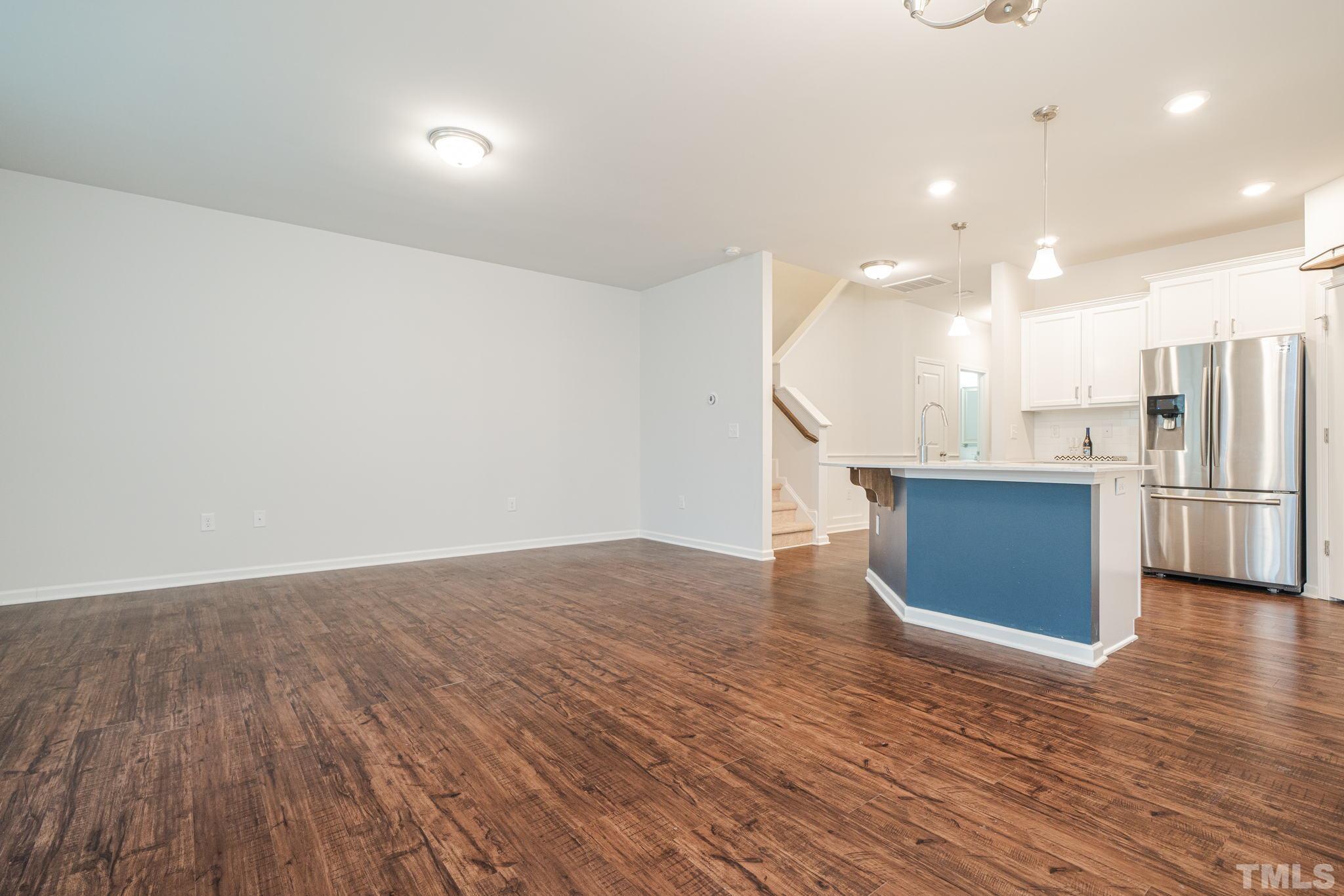 6075 Beale Loop Raleigh, NC 27616 - Photo 8 of 23 a view of a kitchen with a fridge and wooden floor
