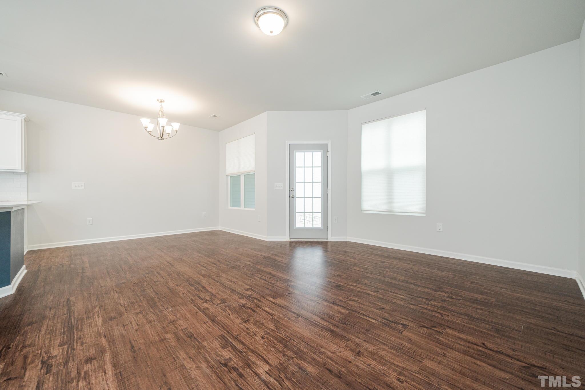 6075 Beale Loop Raleigh, NC 27616 - Photo 10 of 23 an empty room with wooden floor and windows
