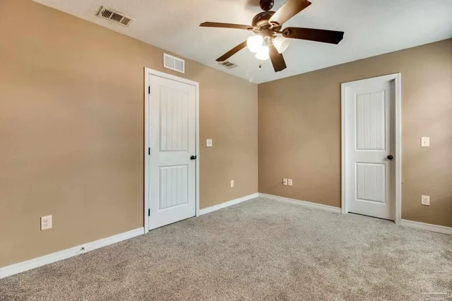 an empty room with closet and a chandelier fan