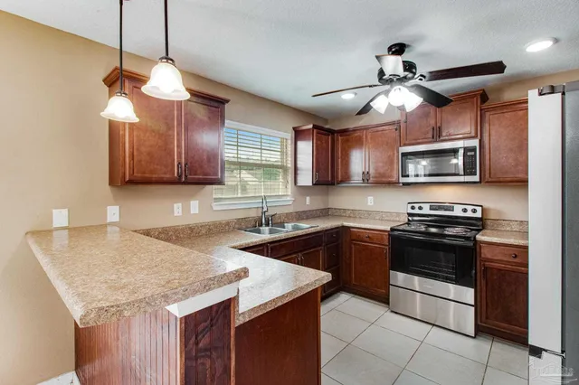 a kitchen with stainless steel appliances granite countertop a stove top oven a sink and dishwasher
