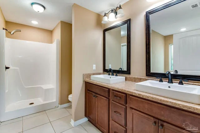 a bathroom with double sink and a mirror