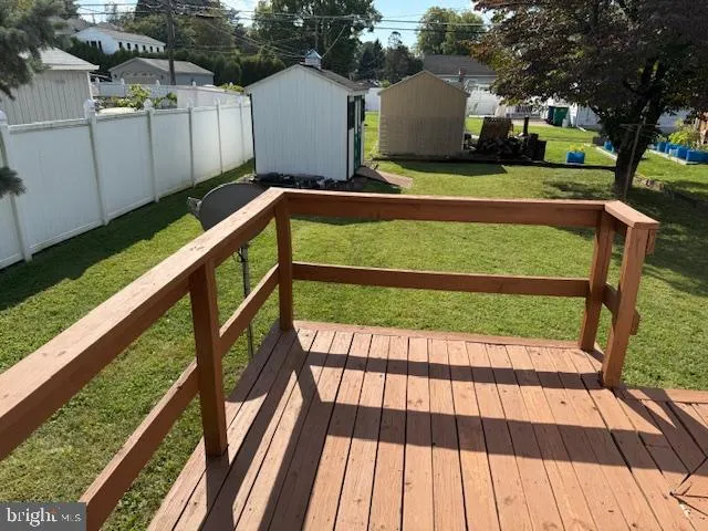 a view of backyard with deck and wooden fence