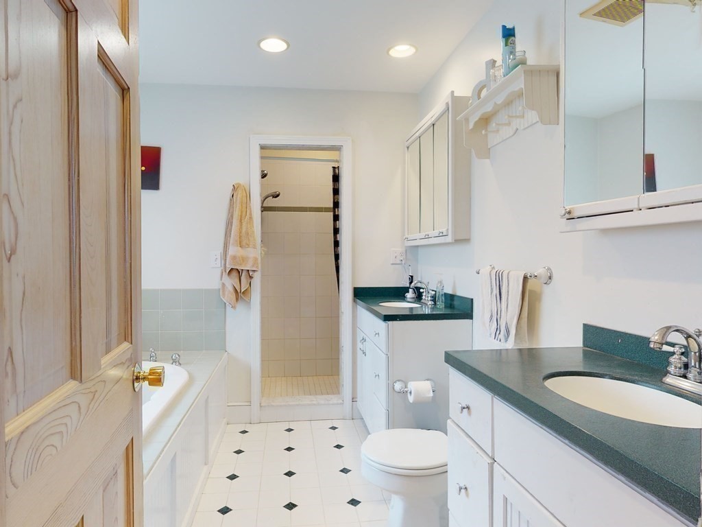 26 Grosvenor Road Waltham, MA 02453 - Photo 26 of 35 a bathroom with a sink a toilet a mirror and shower