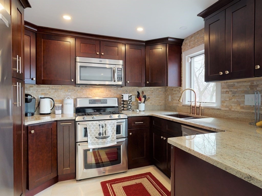 26 Grosvenor Road Waltham, MA 02453 - Photo 3 of 35 a kitchen with stainless steel appliances granite countertop wooden cabinets a sink and a stove