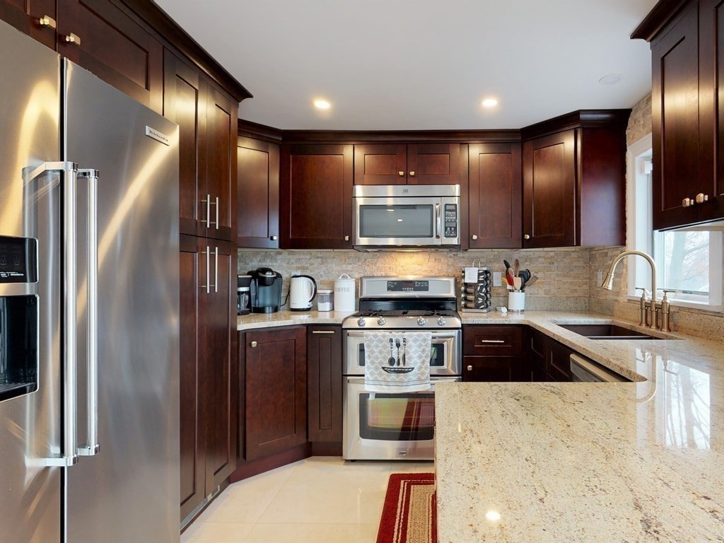 26 Grosvenor Road Waltham, MA 02453 - Photo 4 of 35 a kitchen with stainless steel appliances granite countertop a refrigerator a stove and a sink