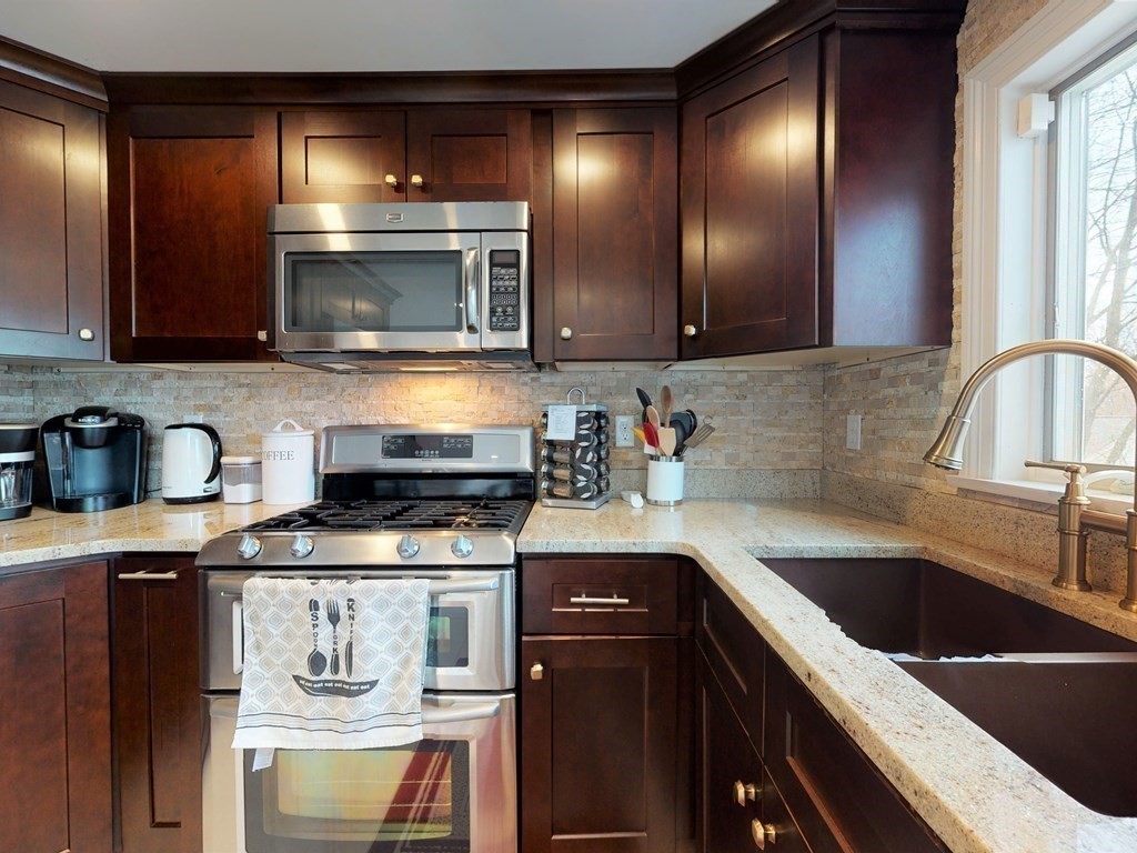 26 Grosvenor Road Waltham, MA 02453 - Photo 5 of 35 a kitchen with stainless steel appliances granite countertop a sink stove and cabinets