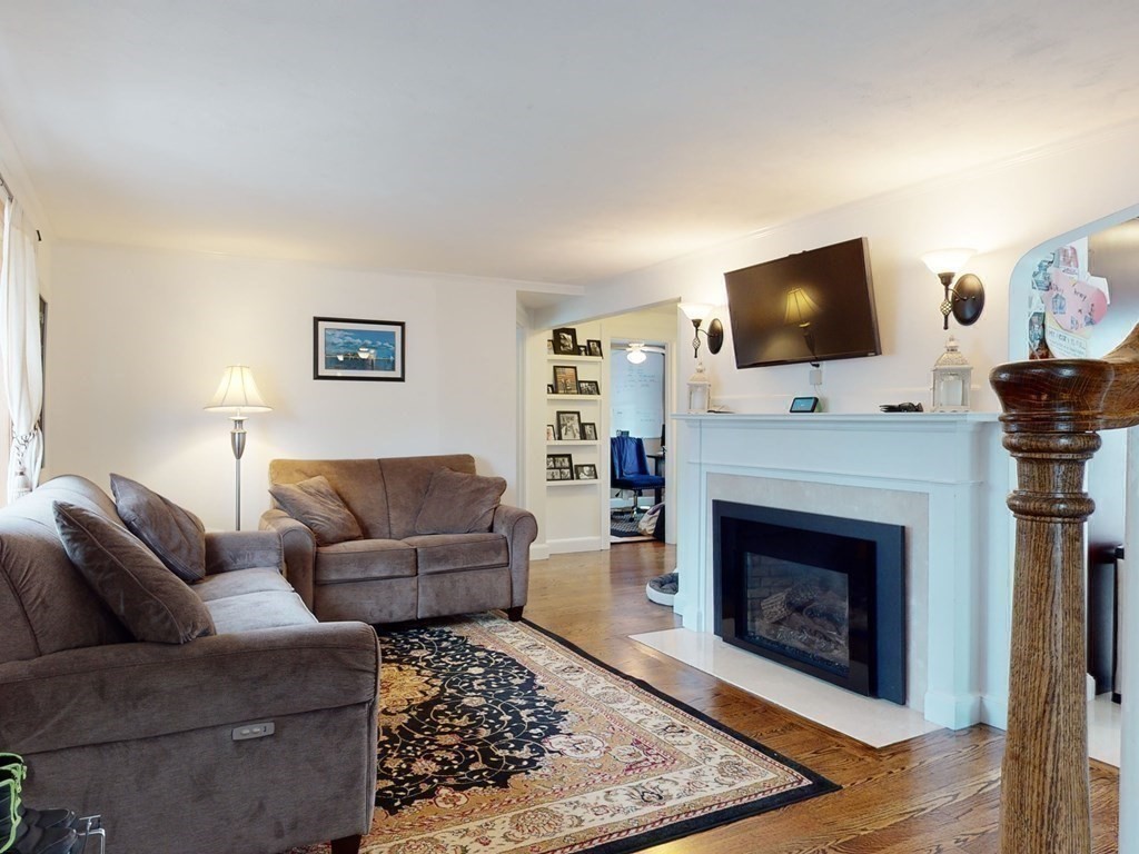 26 Grosvenor Road Waltham, MA 02453 - Photo 10 of 35 a living room with furniture a flat screen tv and a fireplace