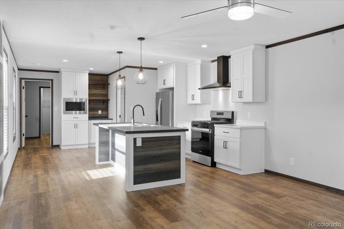230 North 2nd Berthoud, CO 80513 - Photo 3 of 21 a kitchen with stainless steel appliances kitchen island granite countertop a stove a sink and a refrigerator