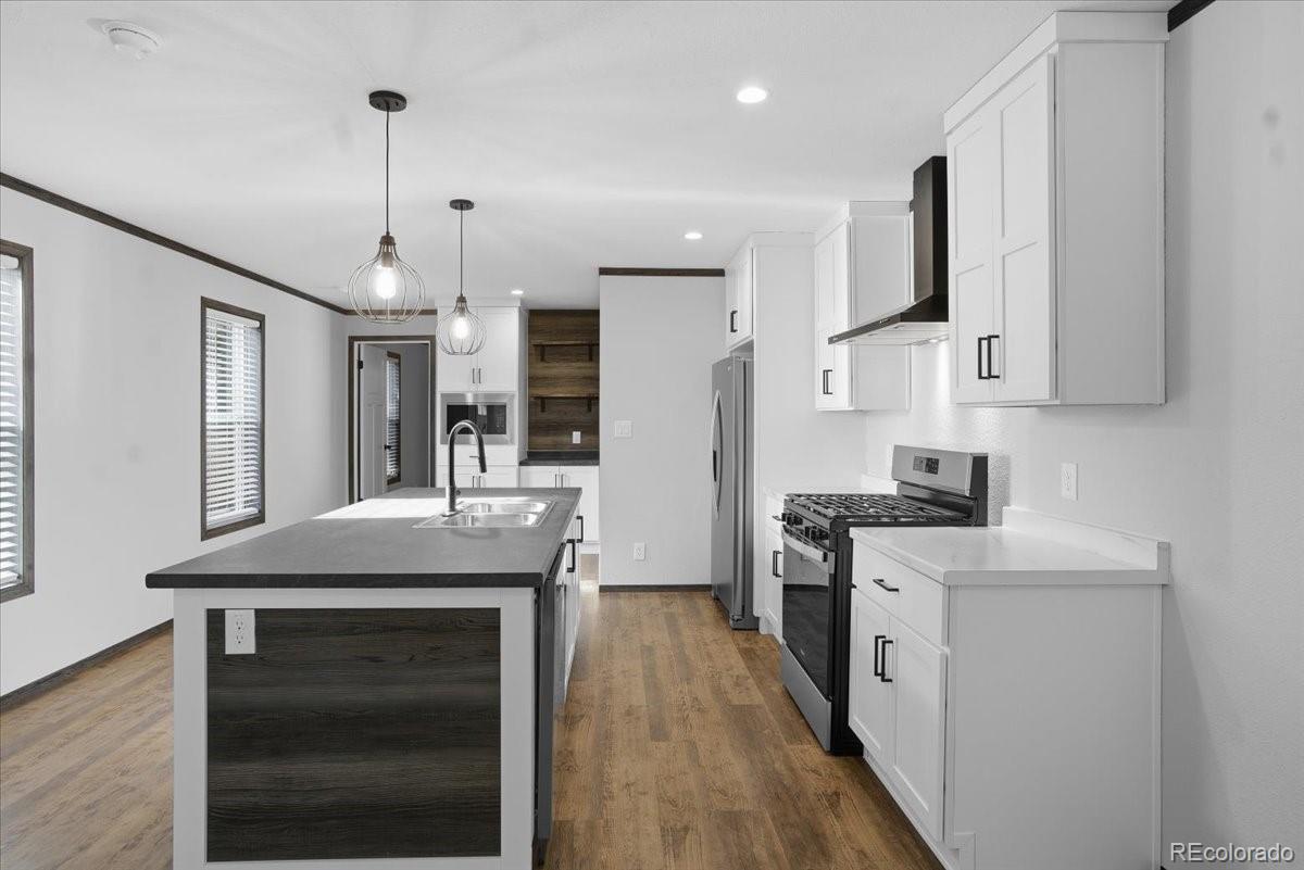 230 North 2nd Berthoud, CO 80513 - Photo 5 of 21 a kitchen with stainless steel appliances kitchen island granite countertop a stove a sink and a refrigerator