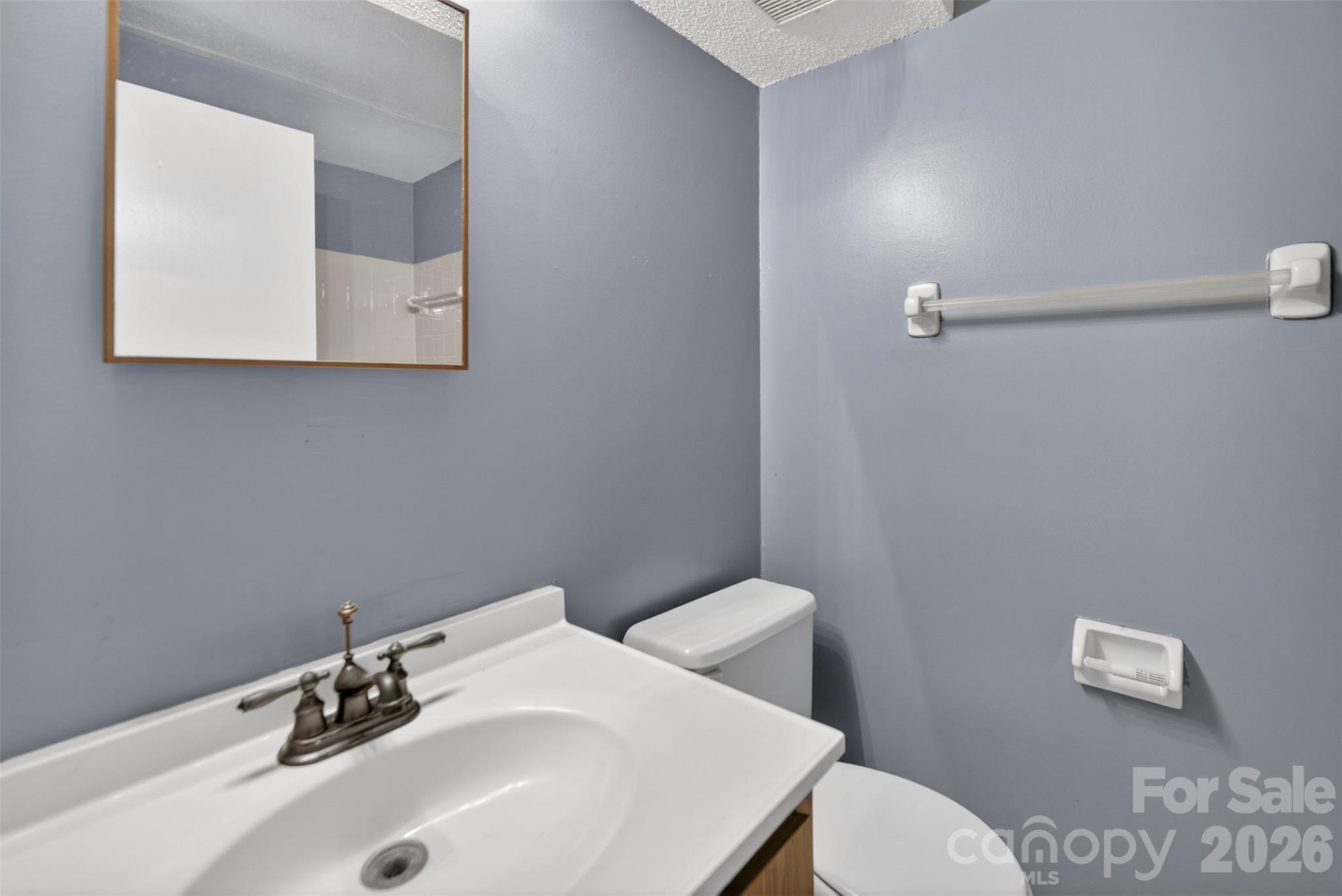 9405 Old Concord Road, Unit C Charlotte, NC 28213 - Photo 16 of 27 a bathroom with a sink a toilet and mirror