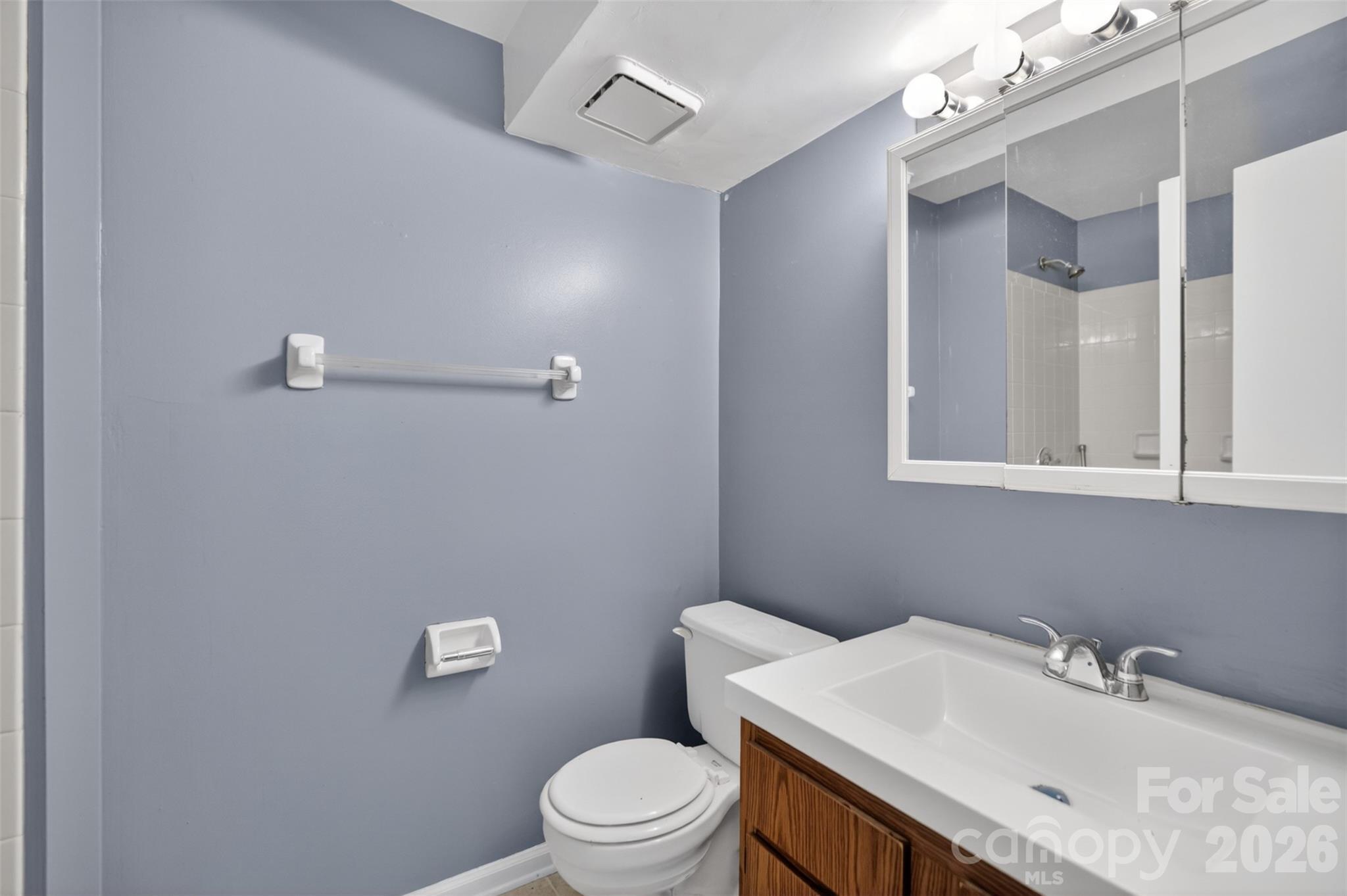 9405 Old Concord Road, Unit C Charlotte, NC 28213 - Photo 21 of 27 a bathroom with a sink a toilet and mirror