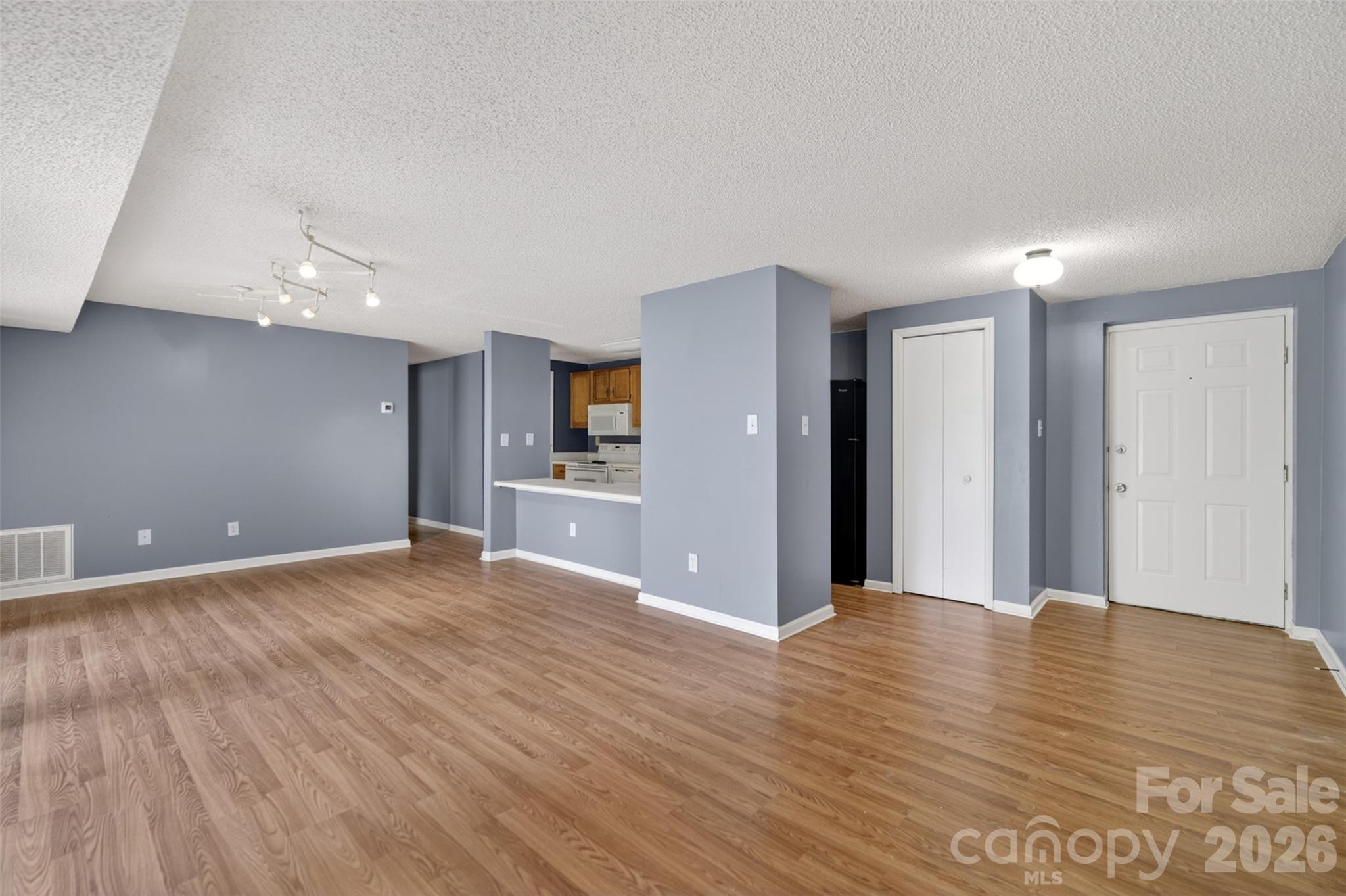 9405 Old Concord Road, Unit C Charlotte, NC 28213 - Photo 4 of 27 a view of an empty room with wooden floor and a kitchen