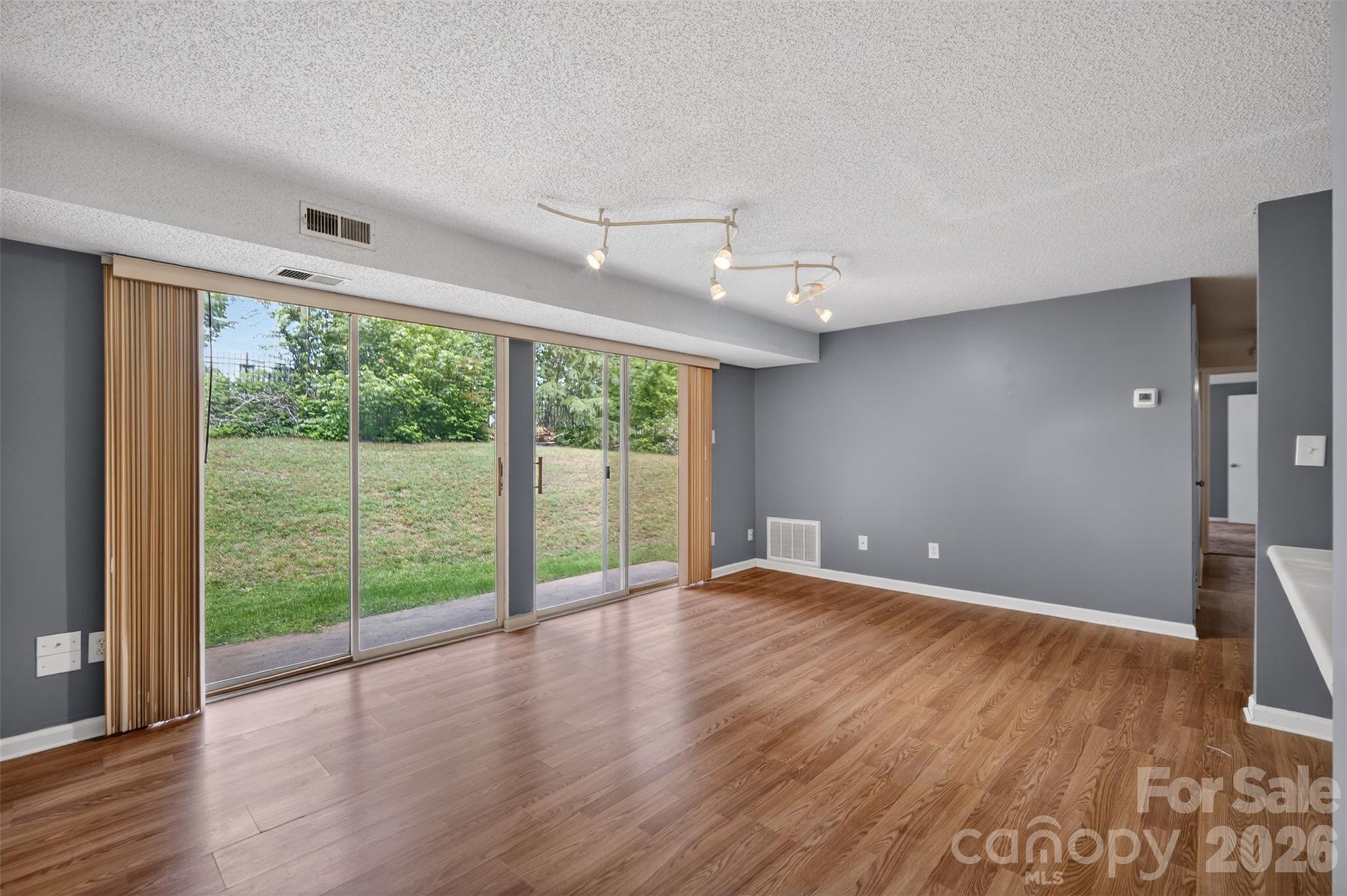 9405 Old Concord Road, Unit C Charlotte, NC 28213 - Photo 6 of 27 a view of an empty room with wooden floor and a window