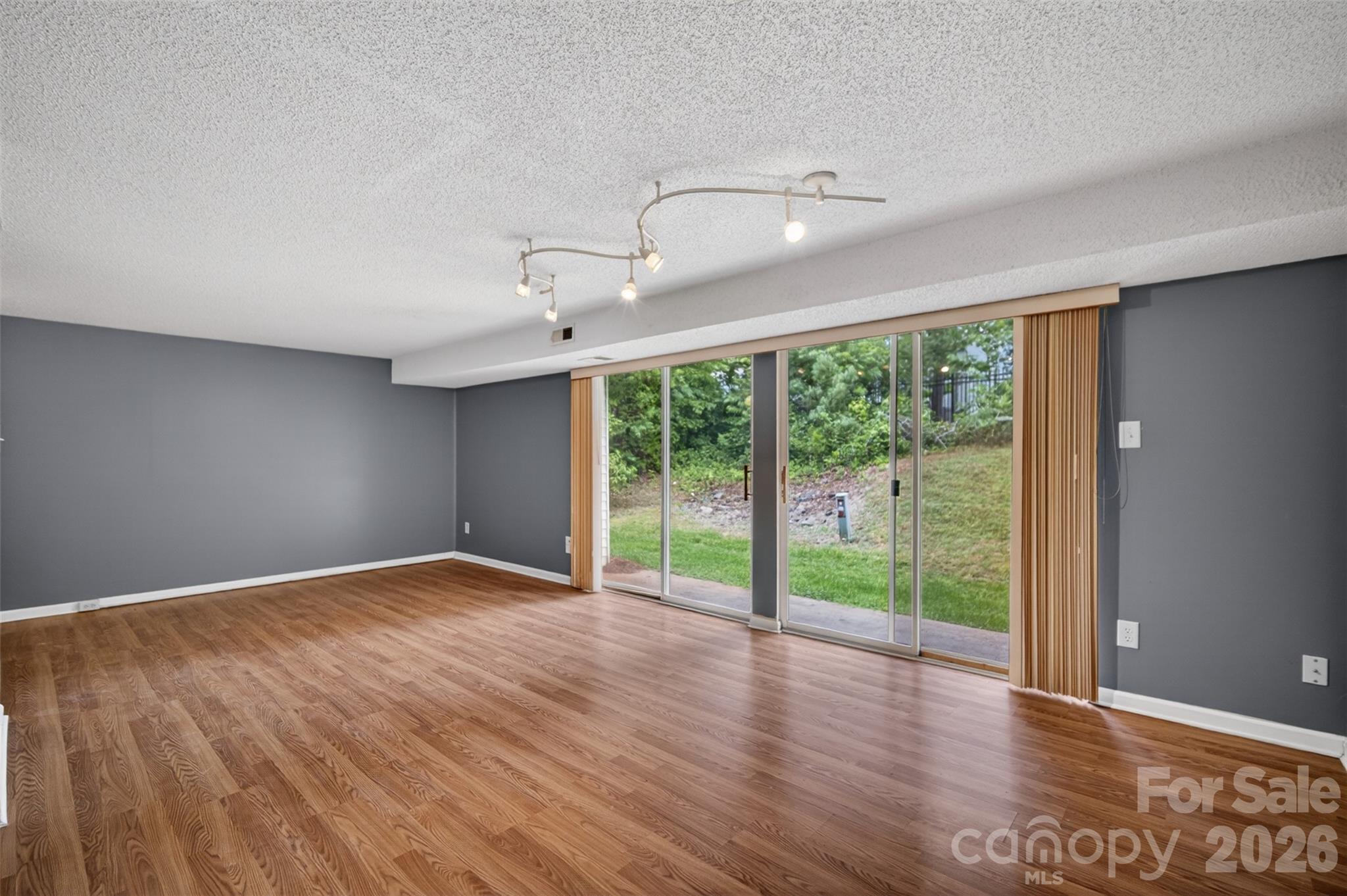 9405 Old Concord Road, Unit C Charlotte, NC 28213 - Photo 7 of 27 a view of an empty room with wooden floor and a window