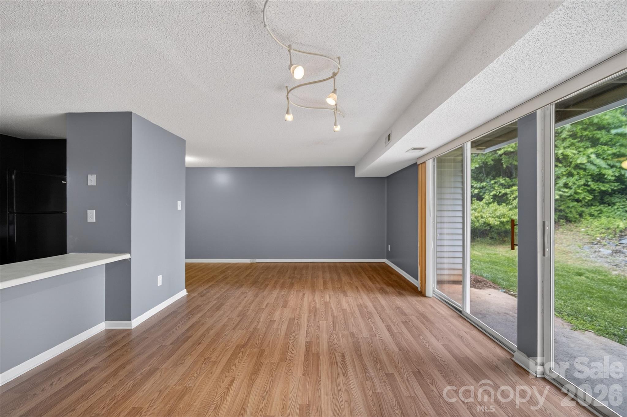 9405 Old Concord Road, Unit C Charlotte, NC 28213 - Photo 8 of 27 a view of empty room with wooden floor and fan
