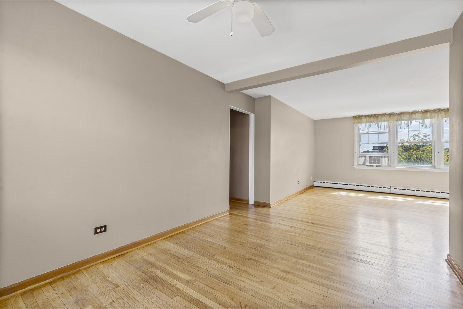 2434 West Farragut Avenue, Unit 3B Chicago, IL 60625 - Photo 5 of 20 an empty room with wooden floor and windows