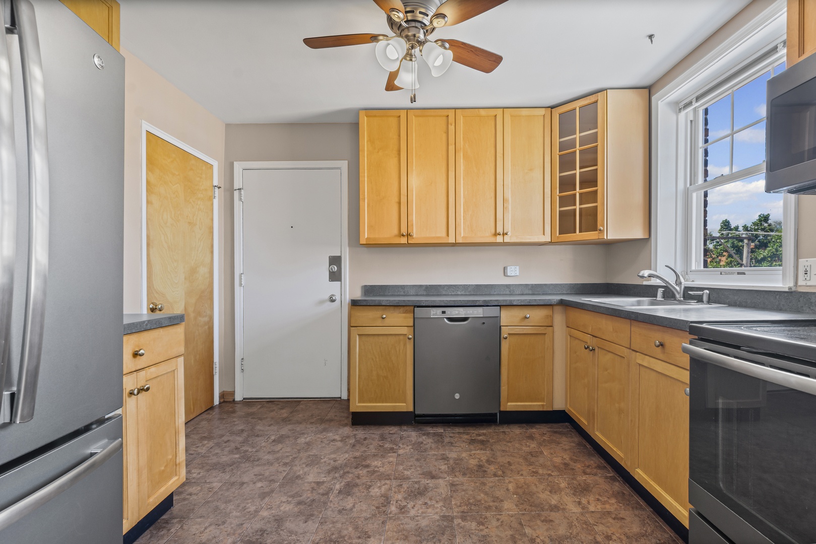 2434 West Farragut Avenue, Unit 3B Chicago, IL 60625 - Photo 6 of 20 a kitchen with stainless steel appliances granite countertop a sink and a refrigerator