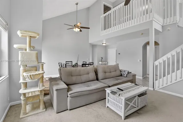 a living room with furniture a ceiling fan and a rug