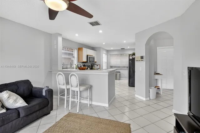 a living room with furniture a kitchen view and a fireplace